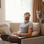 young-attractive-smiling-guy-is-browsing-his-laptop_135932-11236